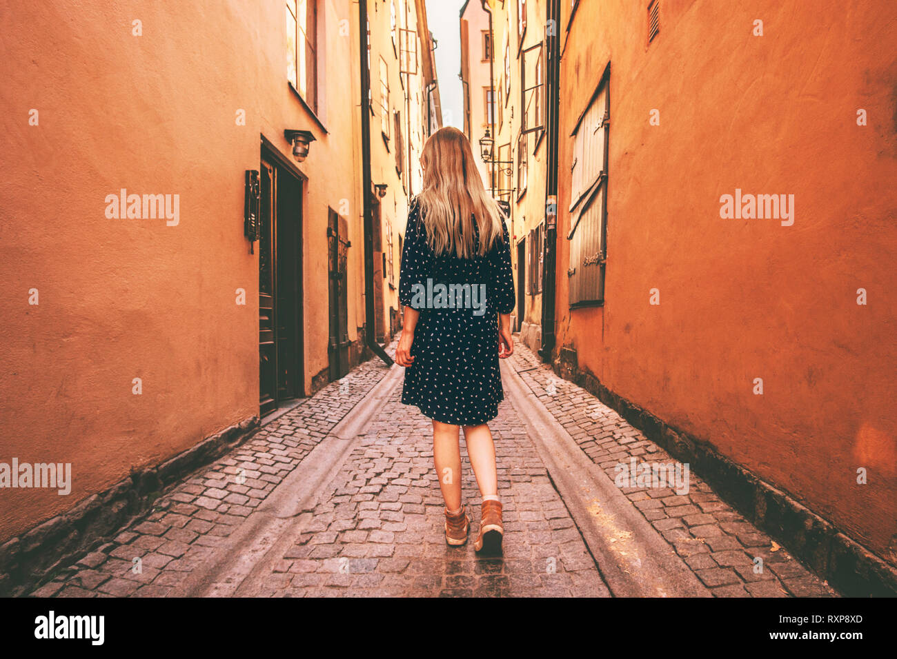 Giovane donna camminare da solo a Stoccolma lo stile di vita di viaggi vacanze estive in Svezia città vecchia strada di ciottoli Foto Stock