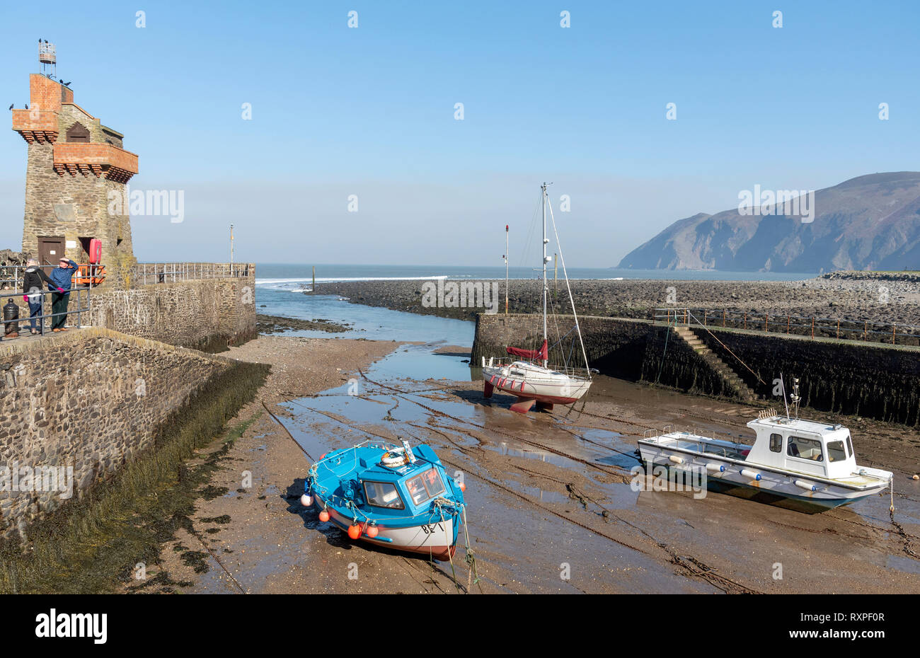 Lynmouth, North Devon, Inghilterra, Regno Unito. Marzo 2019. Lynmouth pier il West Lyn fiume con la storica Torre renana Foto Stock