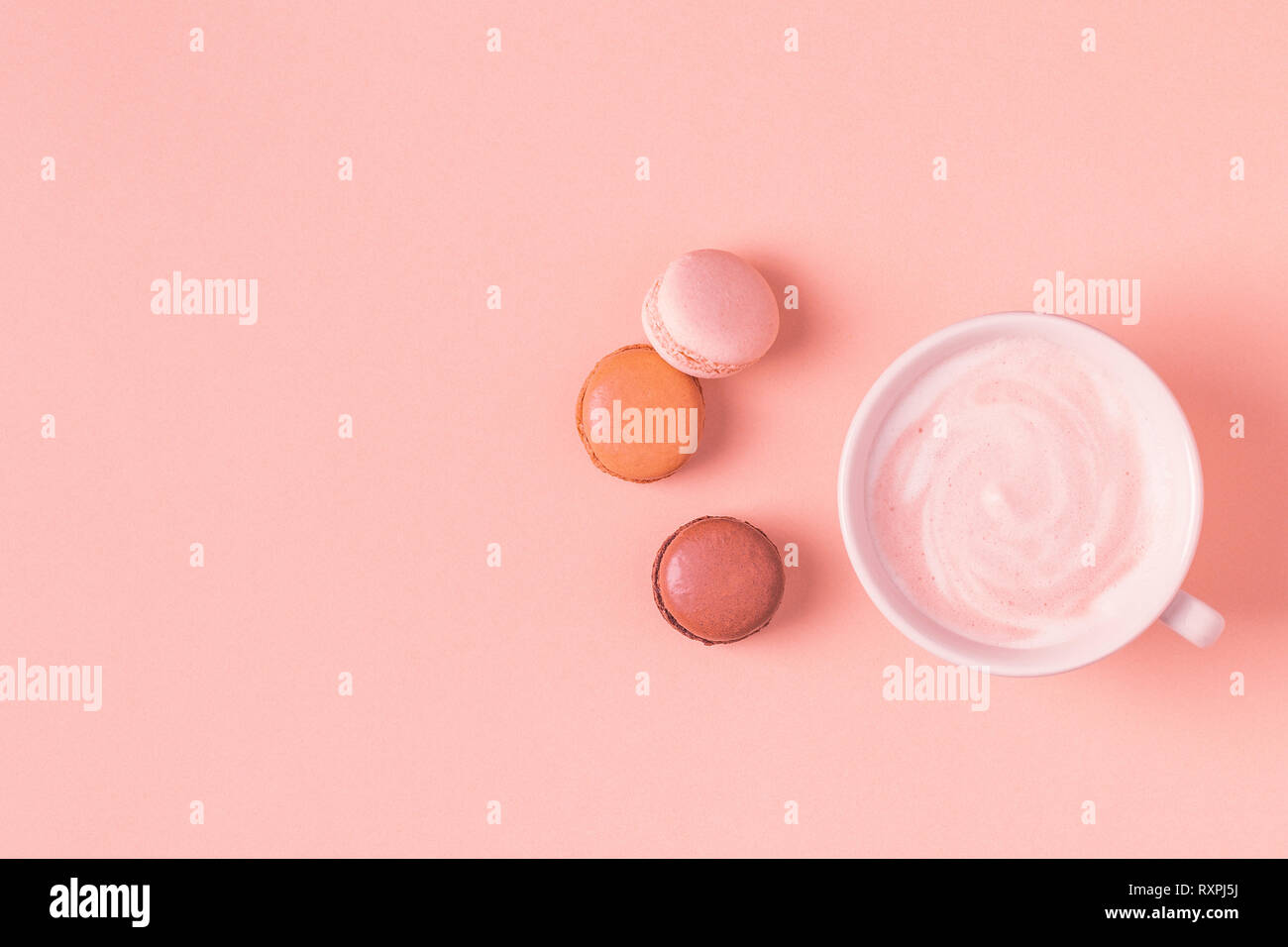 Tazza di caffè con amaretti su sfondo color pastello, piatto laici. Foto Stock