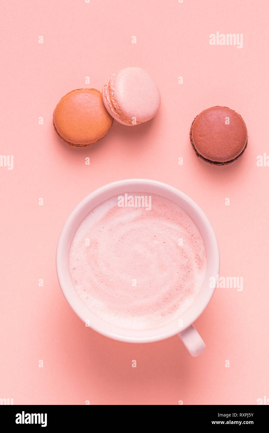 Tazza di caffè con amaretti su sfondo color pastello, piatto laici. Foto Stock