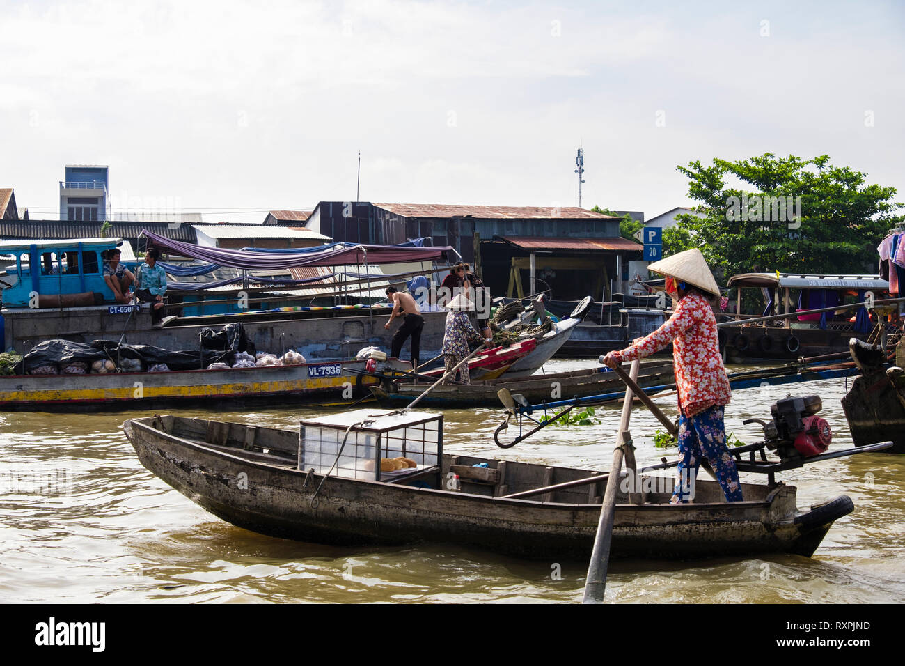 Donna vendita di pani da una piccola barca tradizionale nel mercato galleggiante sul Fiume Hau. Can Tho, Delta del Mekong, Vietnam Asia Foto Stock