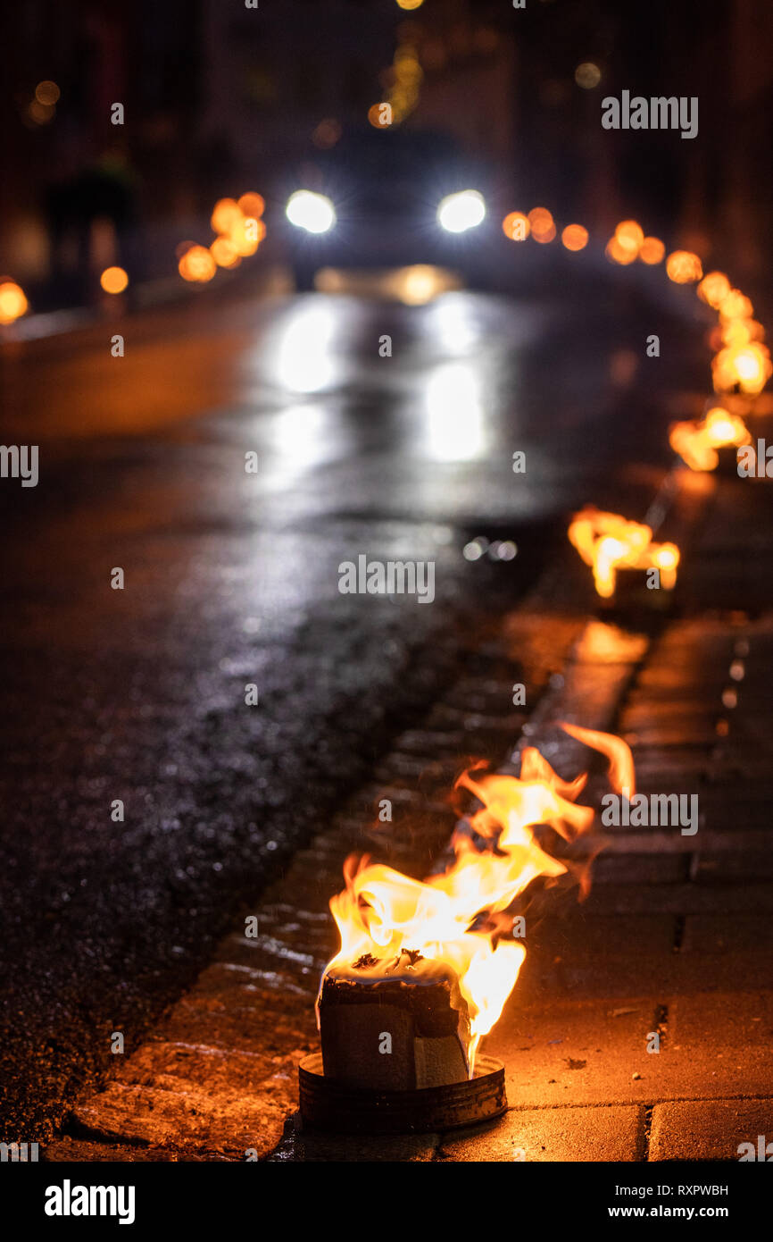 Strada illuminata da piccoli incendi Foto Stock