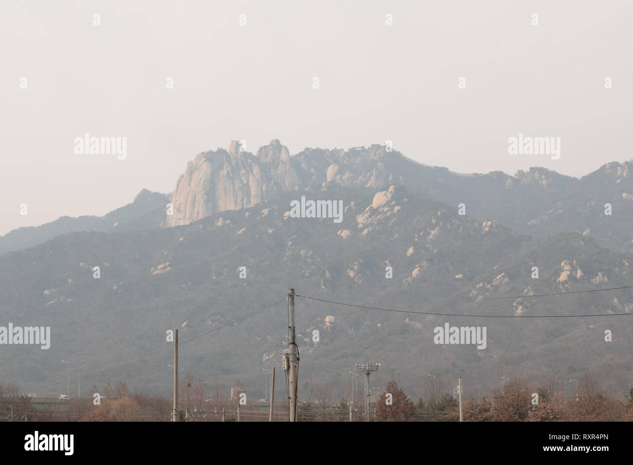Mountain sfuocata dovuta alla fitta la polvere fine. Inquinamento atmosferico a Seoul, Corea del Sud Foto Stock