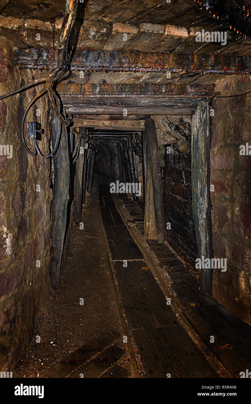 Svuotare vecchia miniera abbandonata albero con timbering in legno e rusty railway Foto Stock