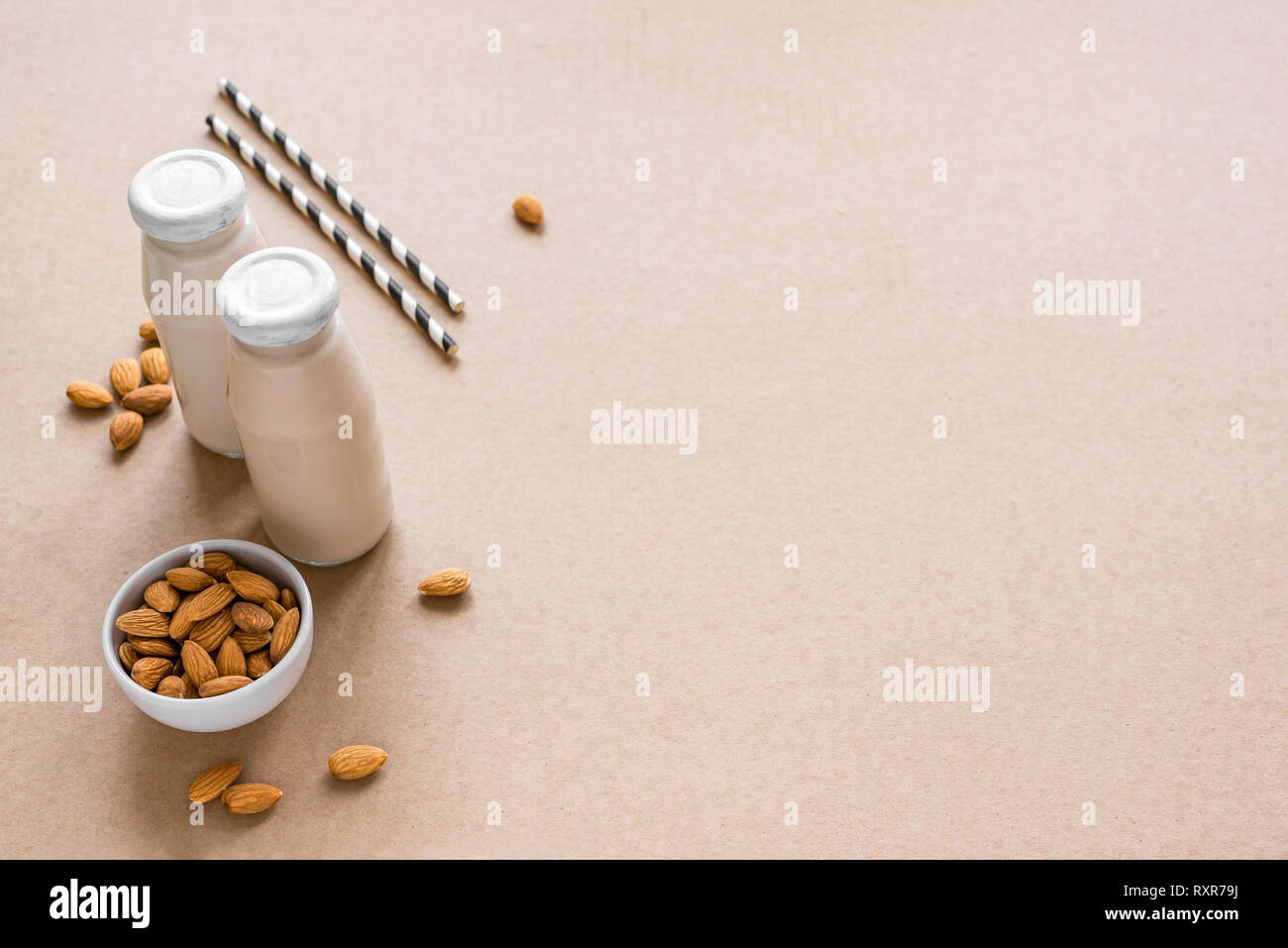 Latte di Mandorla alternativa su sfondo beige, copia dello spazio. Vegano sano sostituto dairy drink gratuito - bottiglia di latte di mandorla. Foto Stock