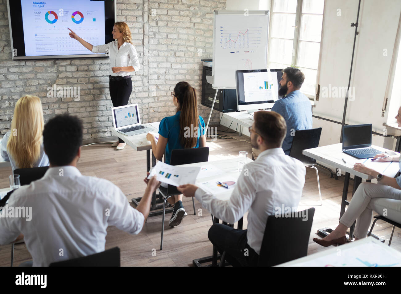 Il successo di una felice gruppo di apprendimento delle persone di ingegneria del software e di business durante la presentazione Foto Stock