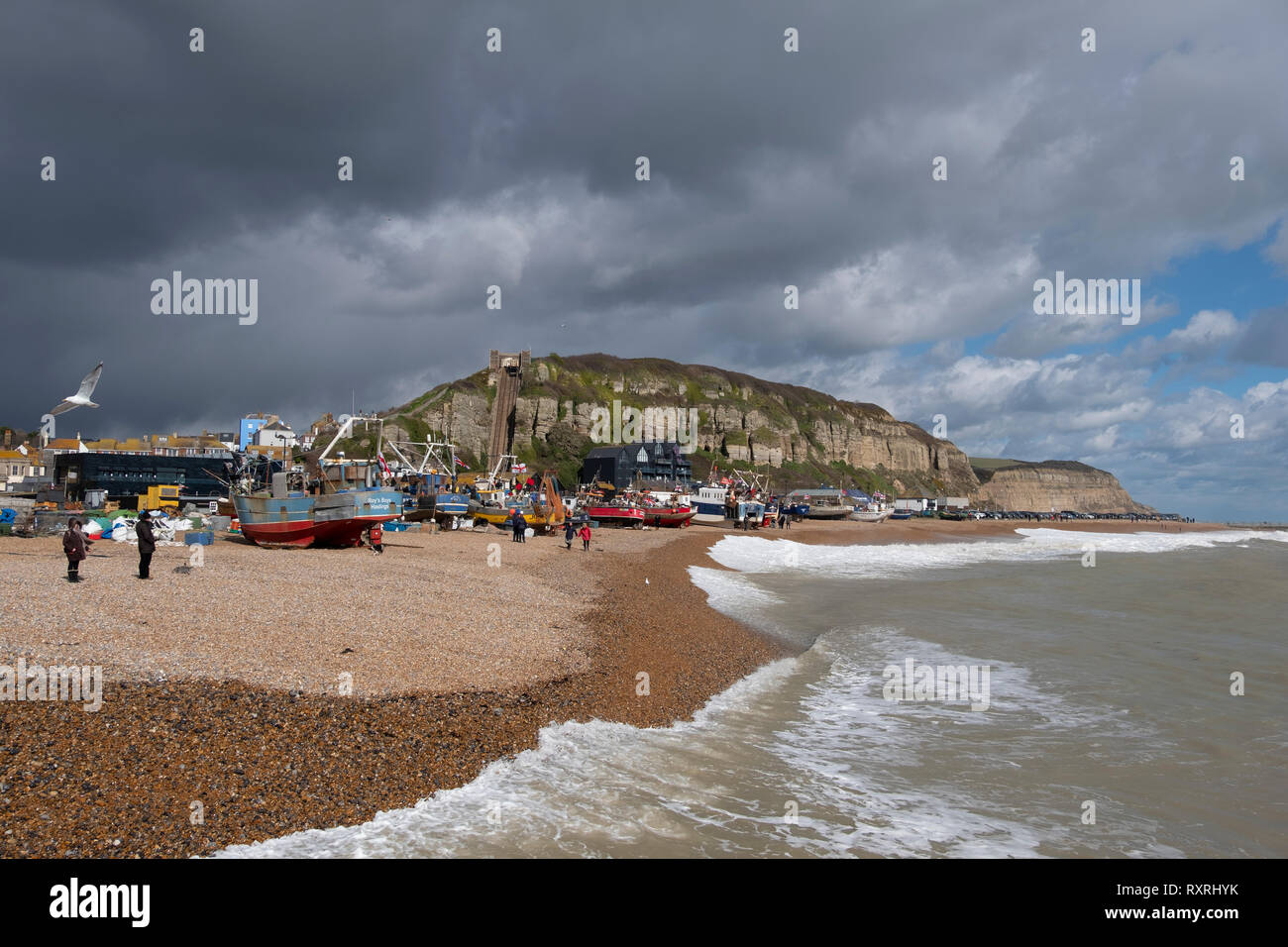 Hastings, East Sussex, Regno Unito. Il 10 marzo 2019. Hastings barche da pesca tirato su in alto sulla spiaggia di Stade, protetta dal mare nuove difese e fuori della portata del mare mosso pilotato da onshore gales. Hastings ha la più grande spiaggia-lanciato Flotta peschereccia commerciale in Europa. Foto Stock