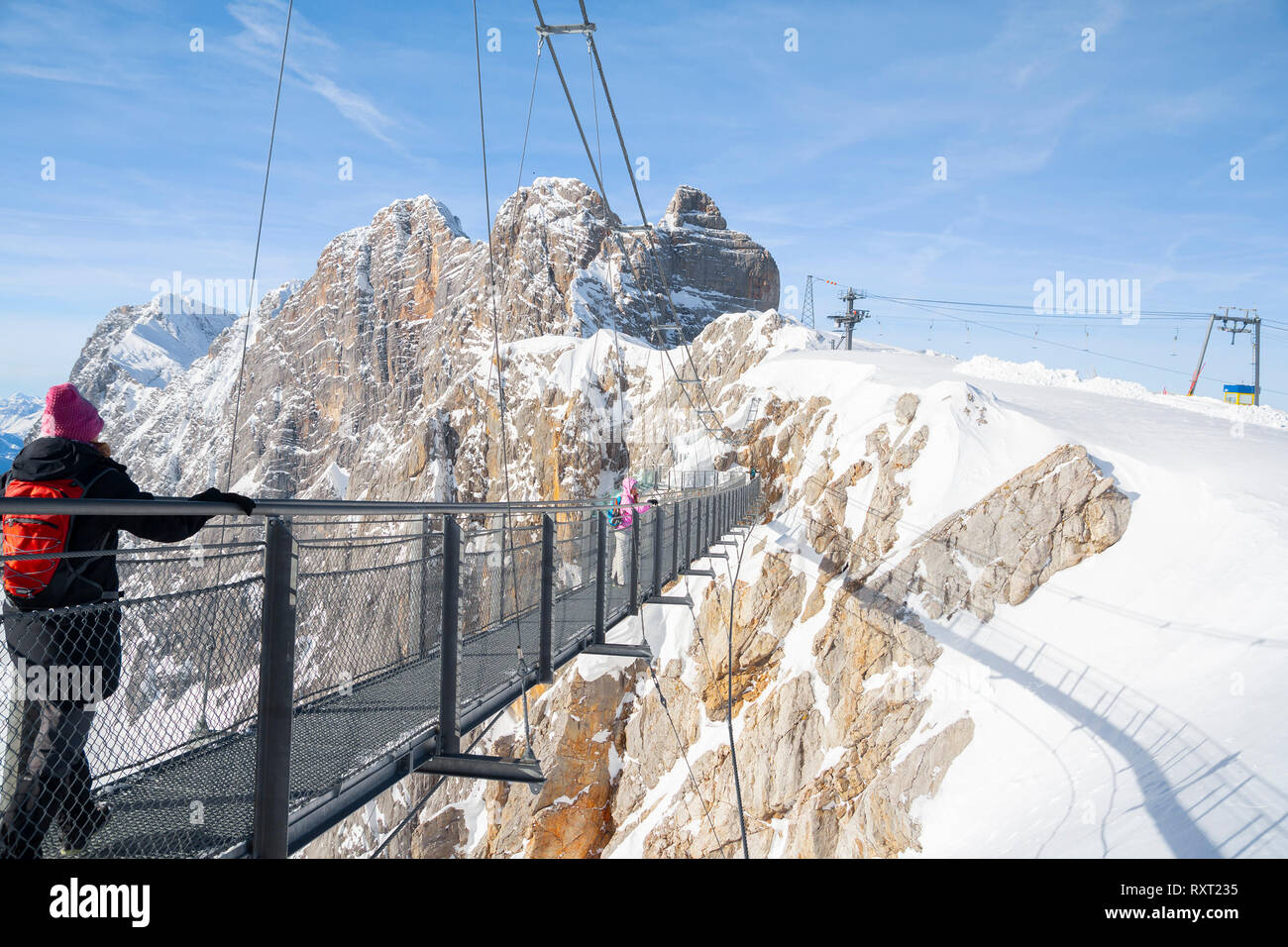 Persone che camminano sulla corda skywalk ponte sulla montagna Dachstein Foto Stock
