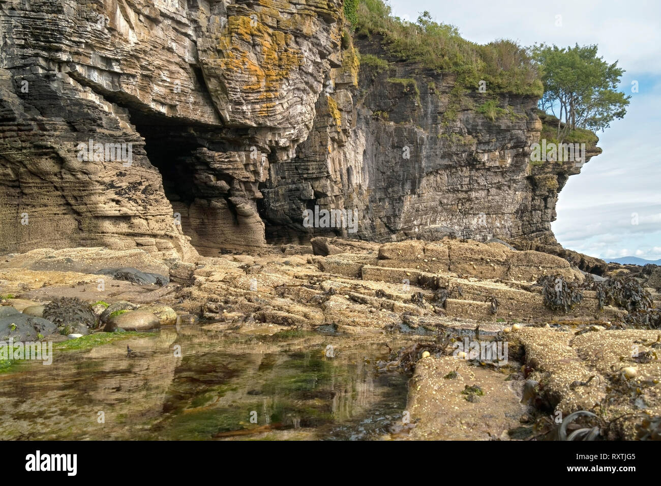 Rocce erose scogliere sul mare e grotte marine con rock pool sul litorale vicino Elgol sull'isola scozzese di Skye, Scotland, Regno Unito Foto Stock