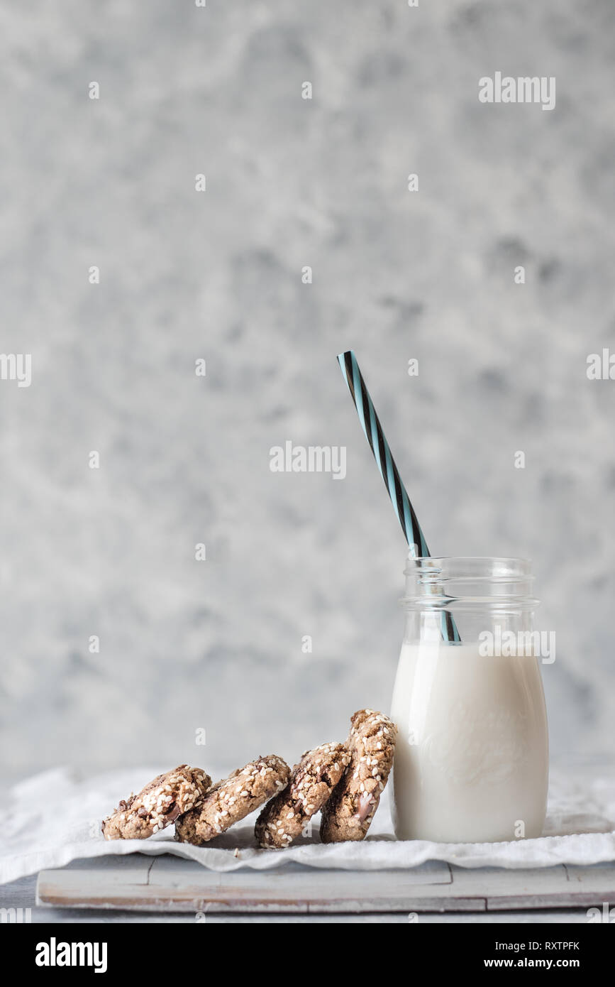 Pila di pane appena sfornato tahini biscotti con scaglie di cioccolato con una bottiglia di latte Foto Stock