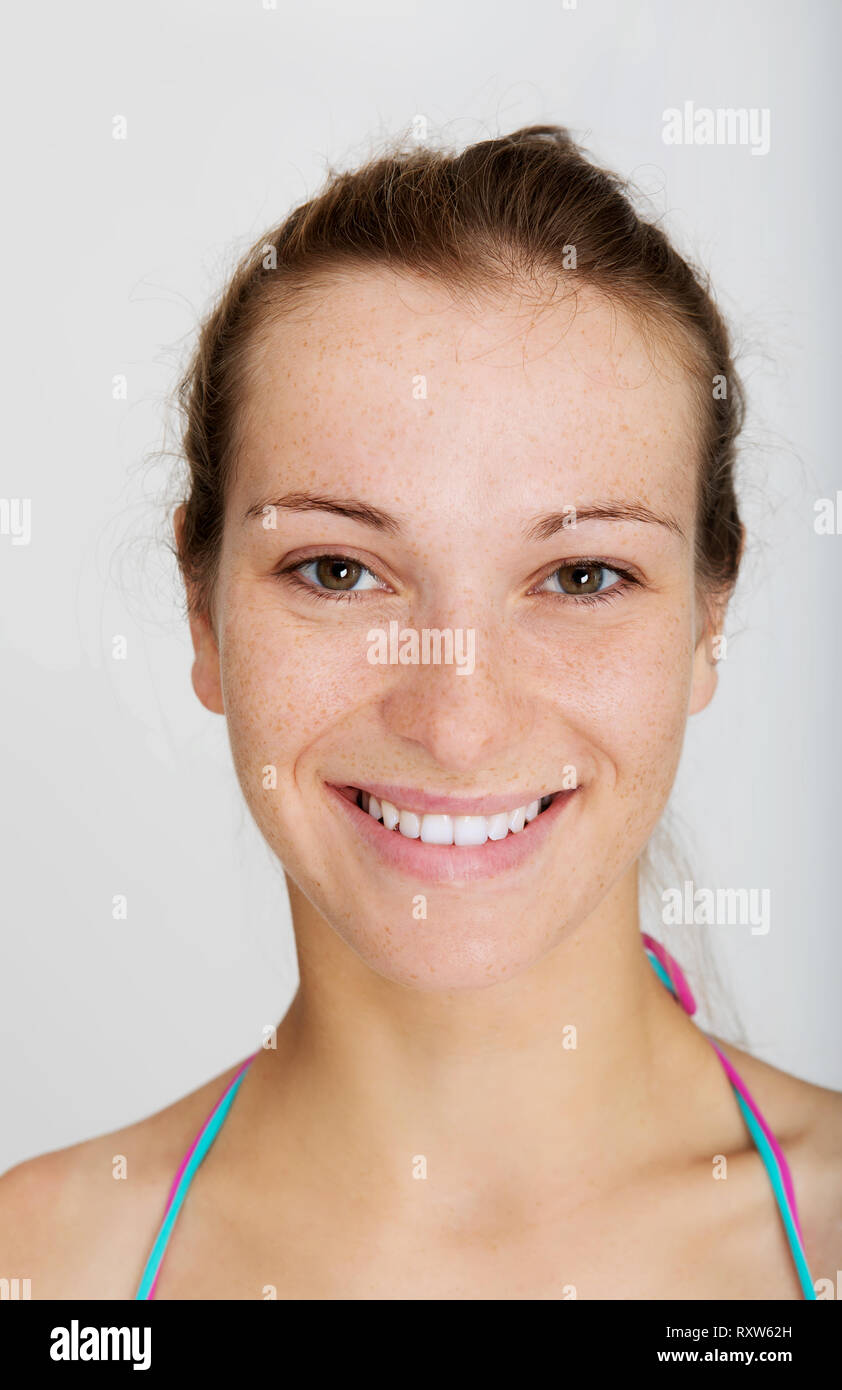 Vista ravvicinata della donna faccia con lentiggini su sfondo bianco. La pelle sensibile. Foto Stock