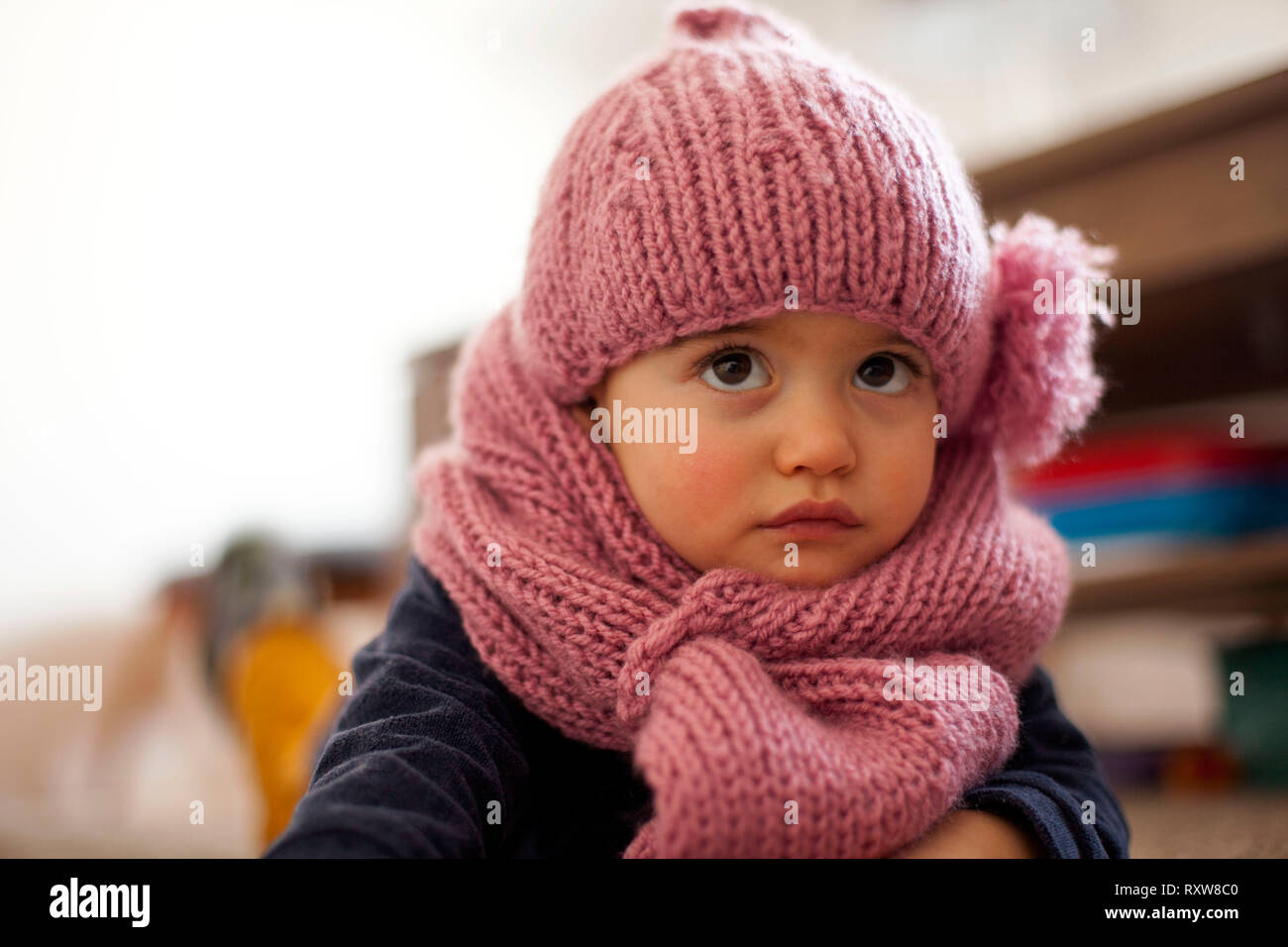 Incantevole piccola bambina indossa viola cappello di lana e sciarpa a caldo Foto Stock