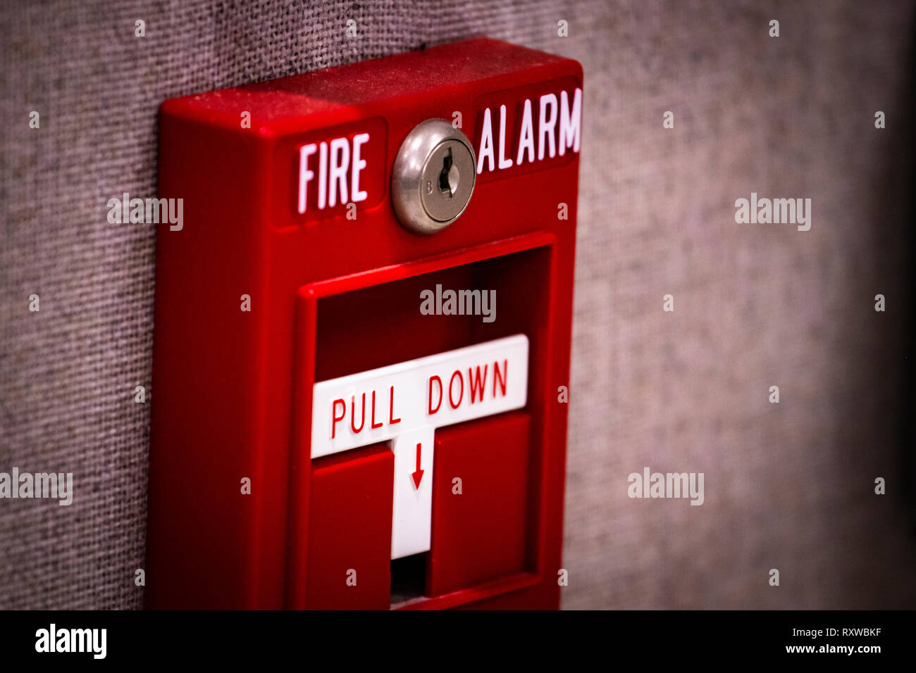 Incendio manuale di attivazione allarme pull station a parete - segnaletica lettura: "ALLARME INCENDIO" e "pull down". Foto Stock