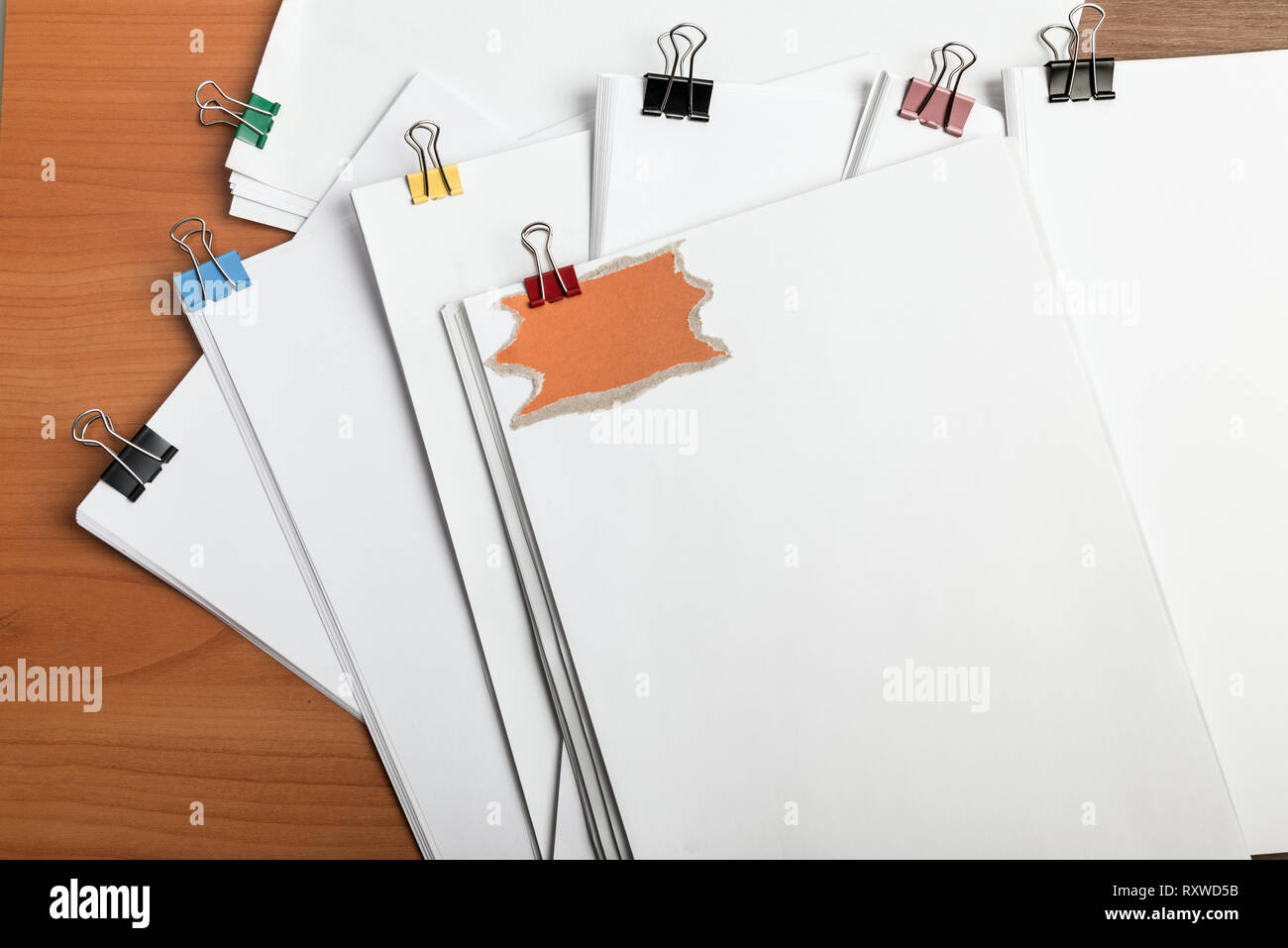 Libro bianco documento con graffe di metallo legante sul tavolo di lavoro vista dall'alto. Forma d'arte nota di Promemoria sul lato anteriore Foto Stock
