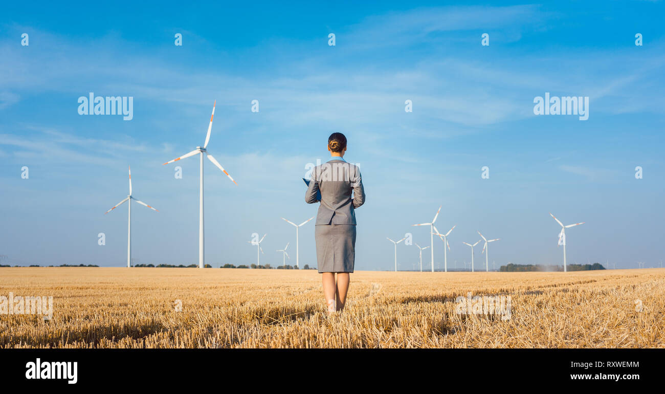 Un investitore in energia verde guardando il suo turbine eoliche Foto Stock
