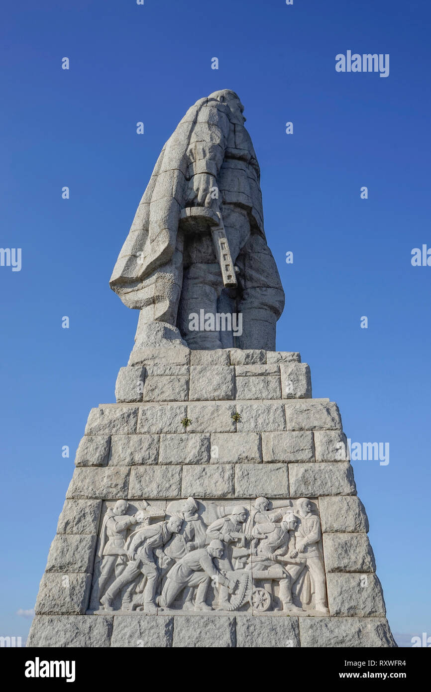 Bassa vantage vista di un monumento dedicato al russo Armata rossa con una statua di pietra del milite ignoto in possesso di una pistola e bassorilievo del advanc Foto Stock