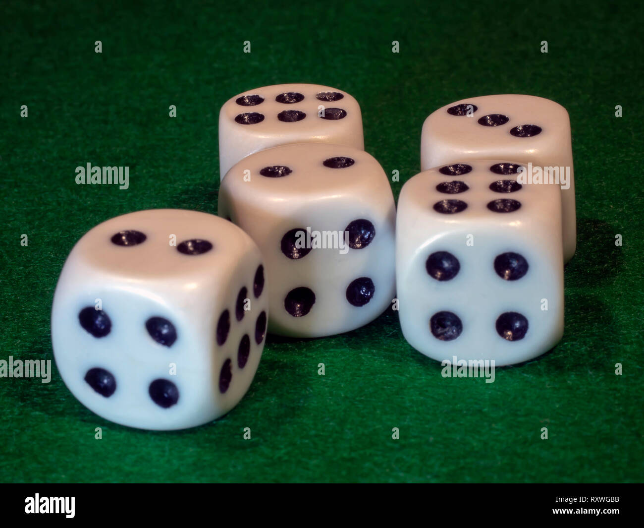 Il cubo di osso di colore bianco con punti neri per gamblings giace sul panno verde. Foto Stock