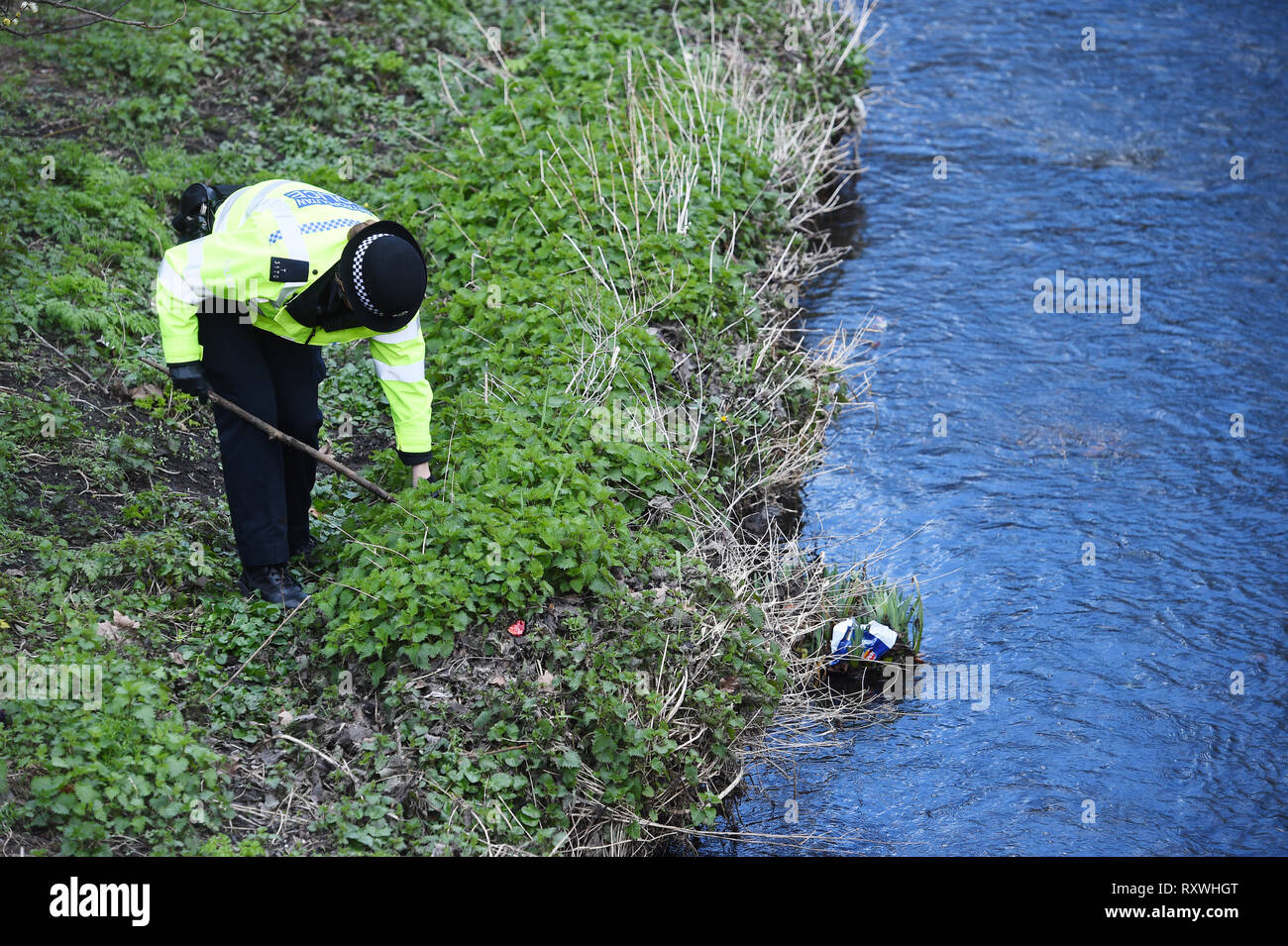 Un ufficiale della Polizia Metropolitana di ricerche per le armi in giardini Cornmill a Lewisham, Londra Sud, come parte dell'operazione scettro, che vedrà le forze in Inghilterra e Galles con scomparti di riscatto, arrestare-e-ricerca armi e spazia in una repressione concordate sul coltello la criminalità. Foto Stock