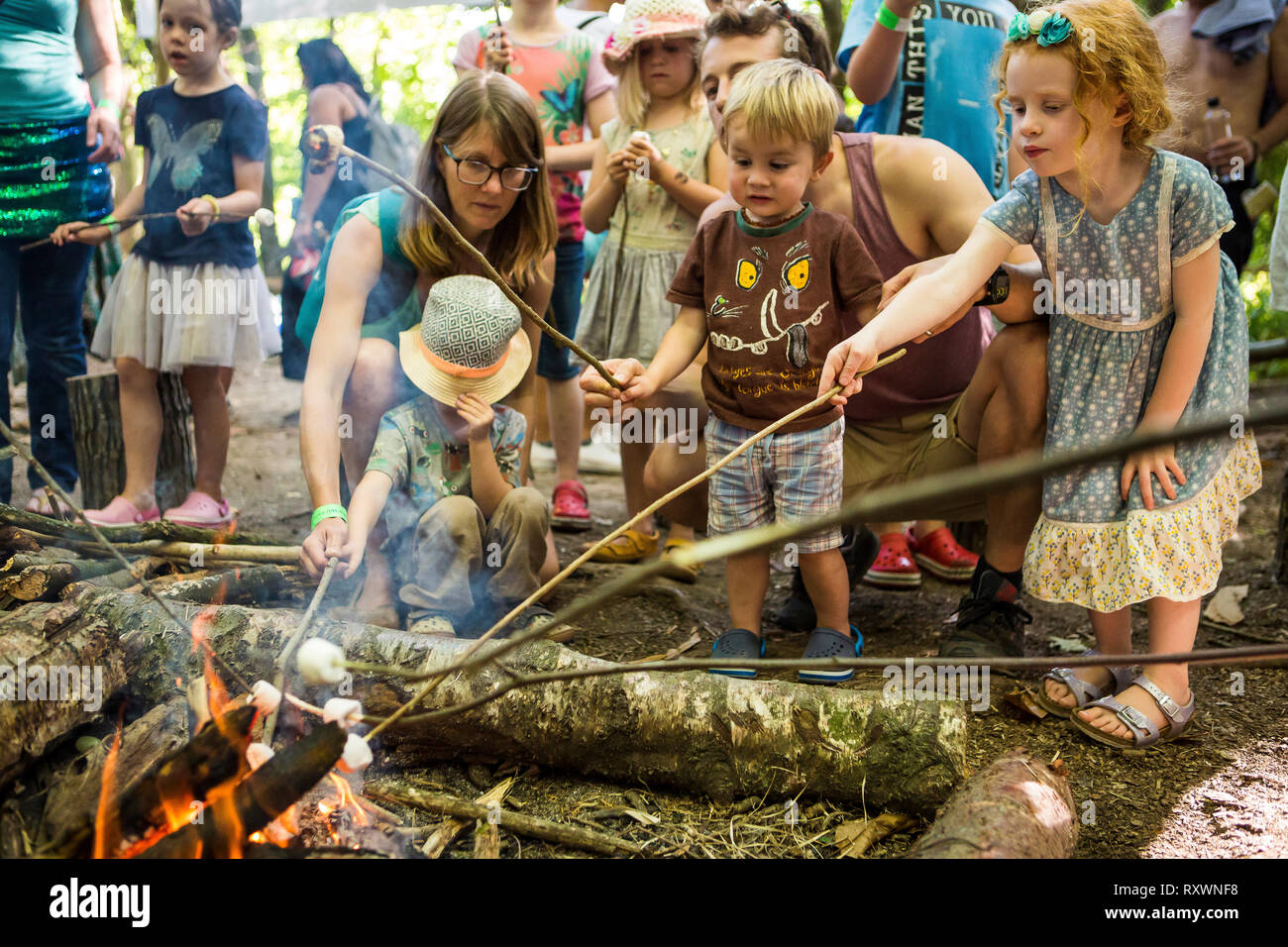 La tostatura marshmallow su un fuoco aperto in corrispondenza di un bosco bushcraft workshop presso nel selvaggio festival, Kent, Regno Unito Foto Stock