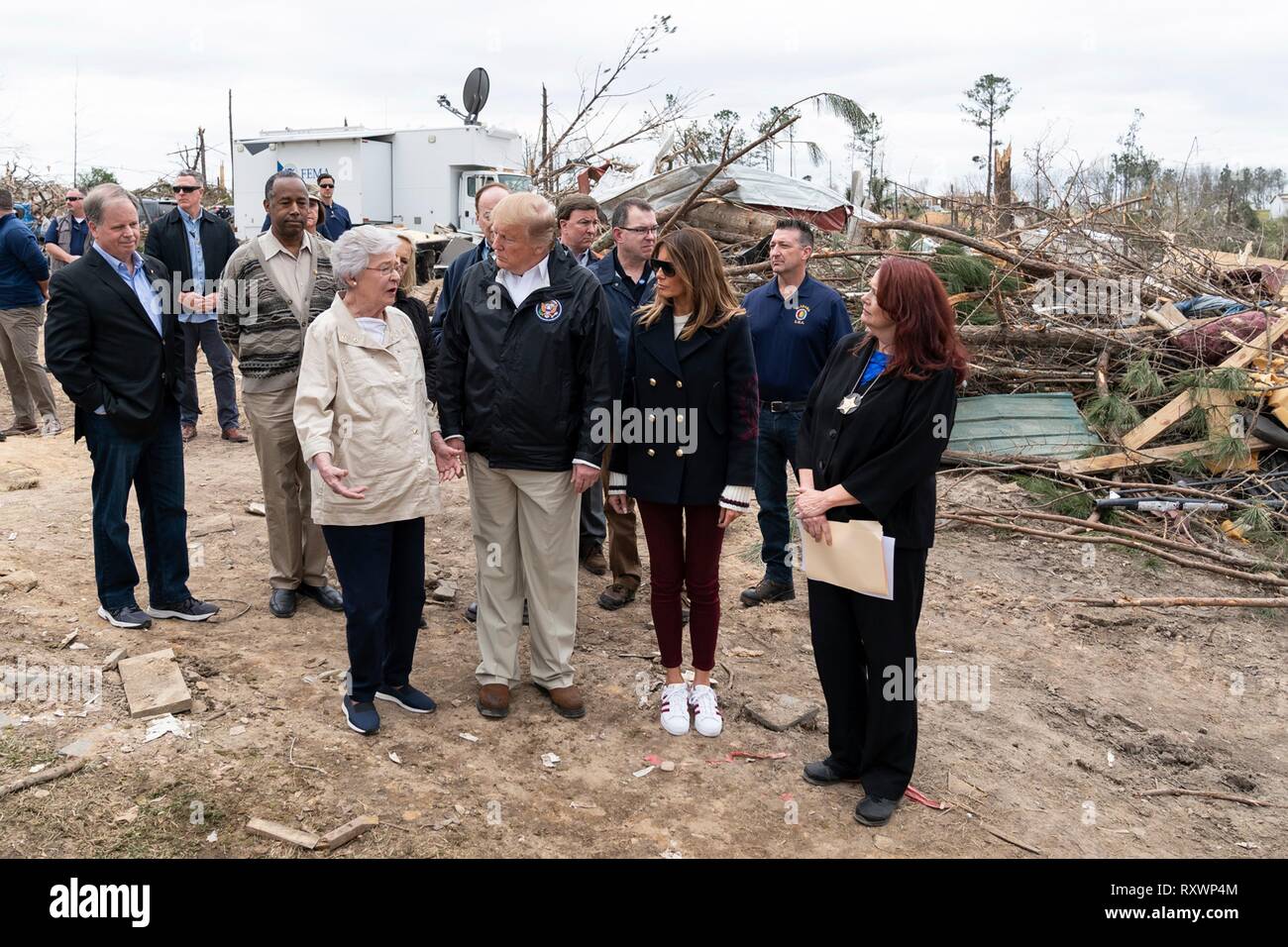 U.S prima signora Melania Trump e presidente Donald Trump a piedi con Gov. Kay Ivey, sinistra, come essi danno vista da un massiccio tornado Marzo 8, 2019 in Lee County, Alabama. La regione è stata colpita da un tornado il 3 marzo uccidendo 23 persone. Foto Stock