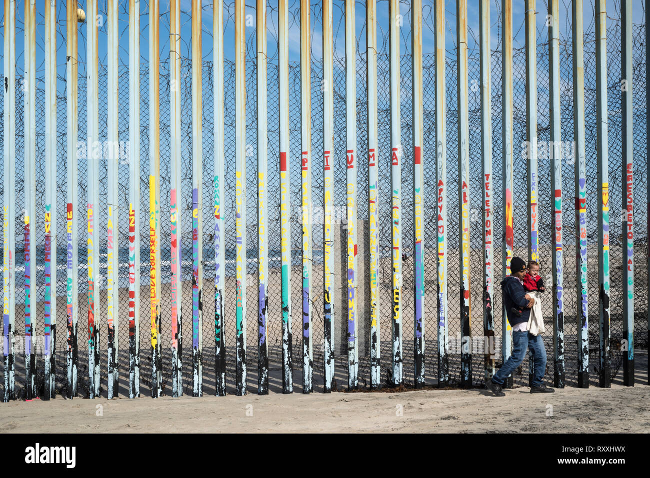 Padre con baby figlio a piedi il messicano del lato nord della frontiera. Foto Stock