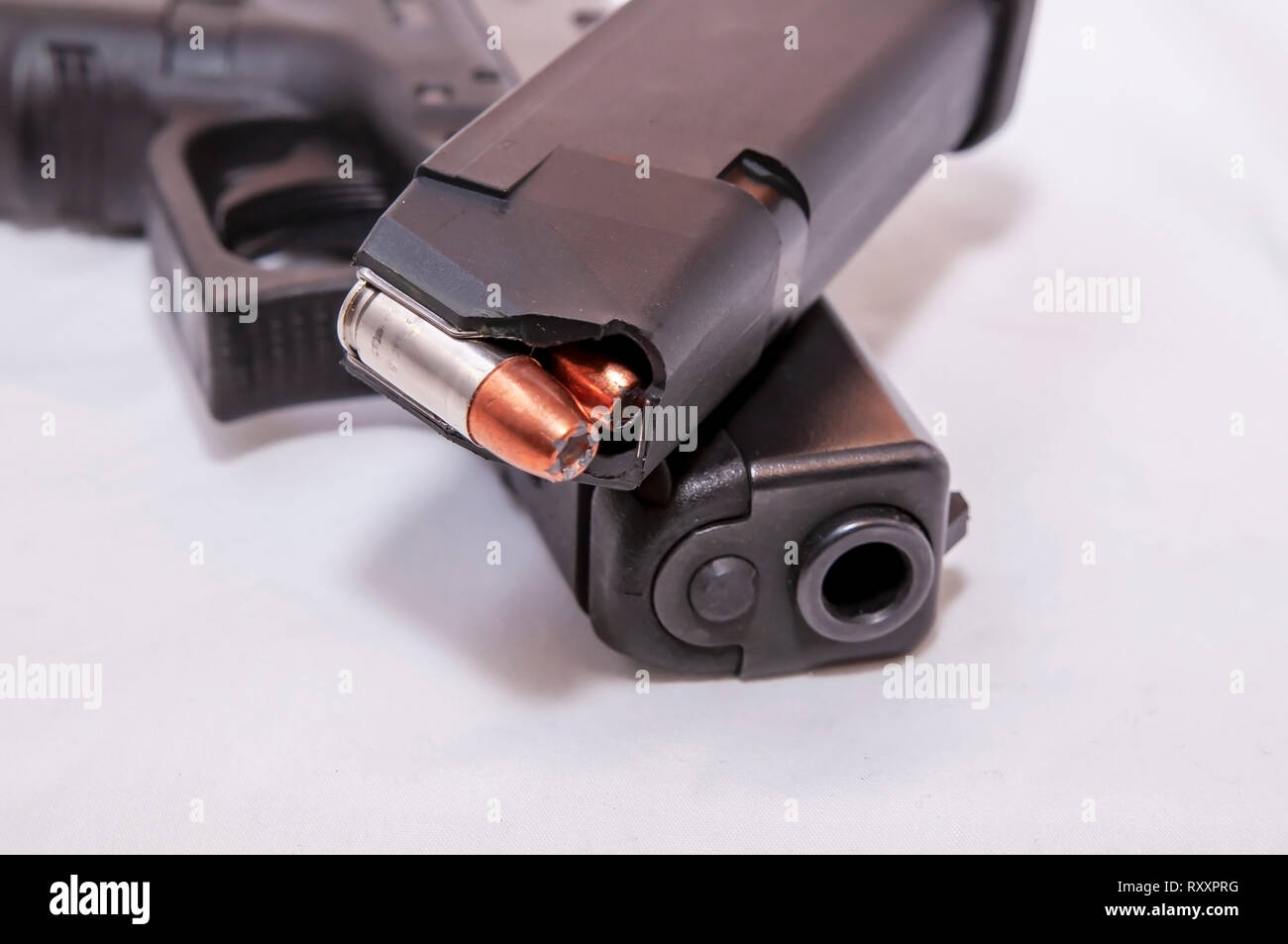 Un nero 9mm pistola con un caricatore con punto di cava elenchi puntati su sfondo bianco Foto Stock