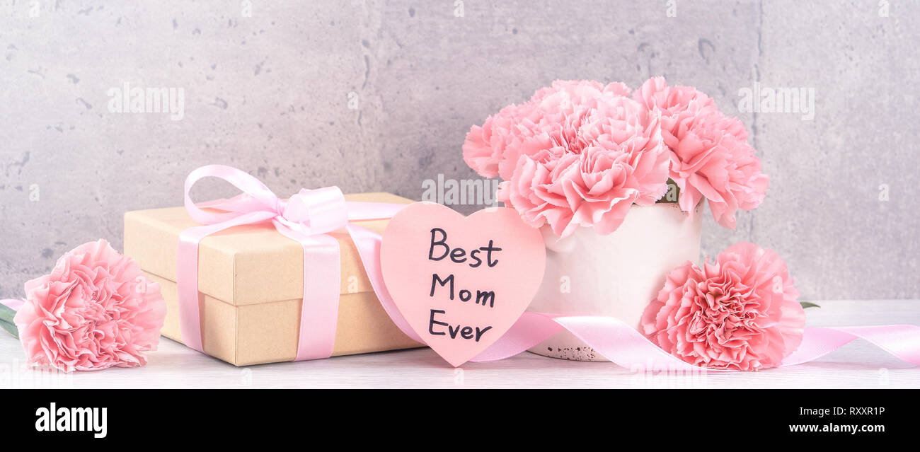 Maggio festa della mamma handmade giftbox auguri fotografia - splendida fioritura garofani con nastro rosa box isolato sul fair-di fronte lo sfondo grigio scrivania, Foto Stock