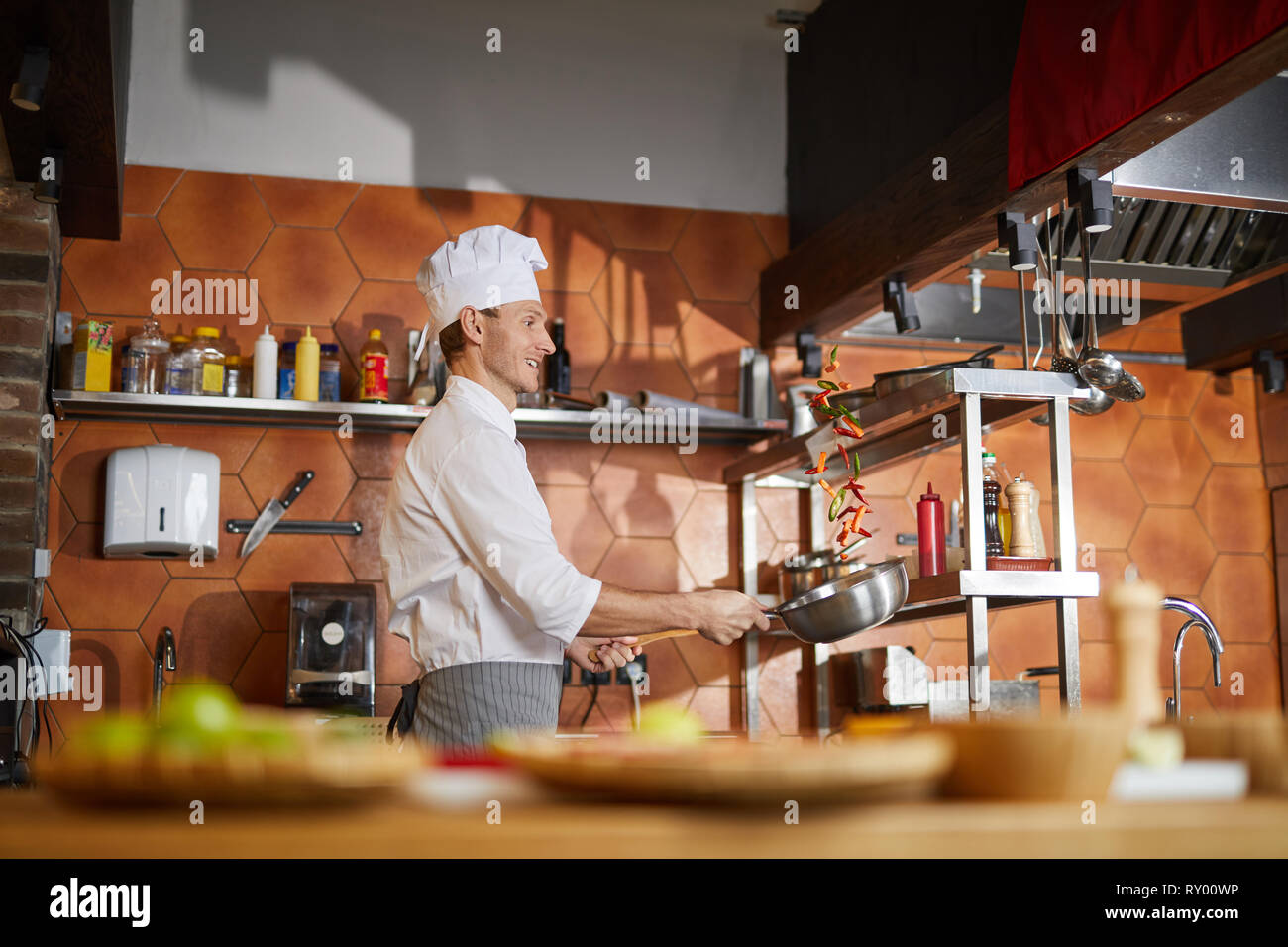 Chef professionale per la cottura in cucina Foto Stock
