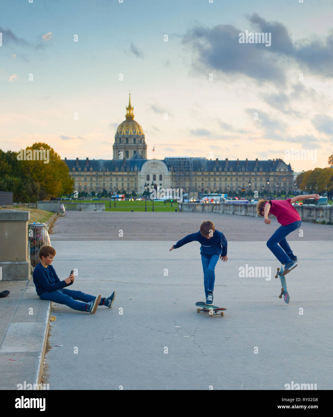 Ragazzo di scattare una foto di pattinaggio teen bambini , il palazzo del parlamento in background, Parigi, Francia Foto Stock