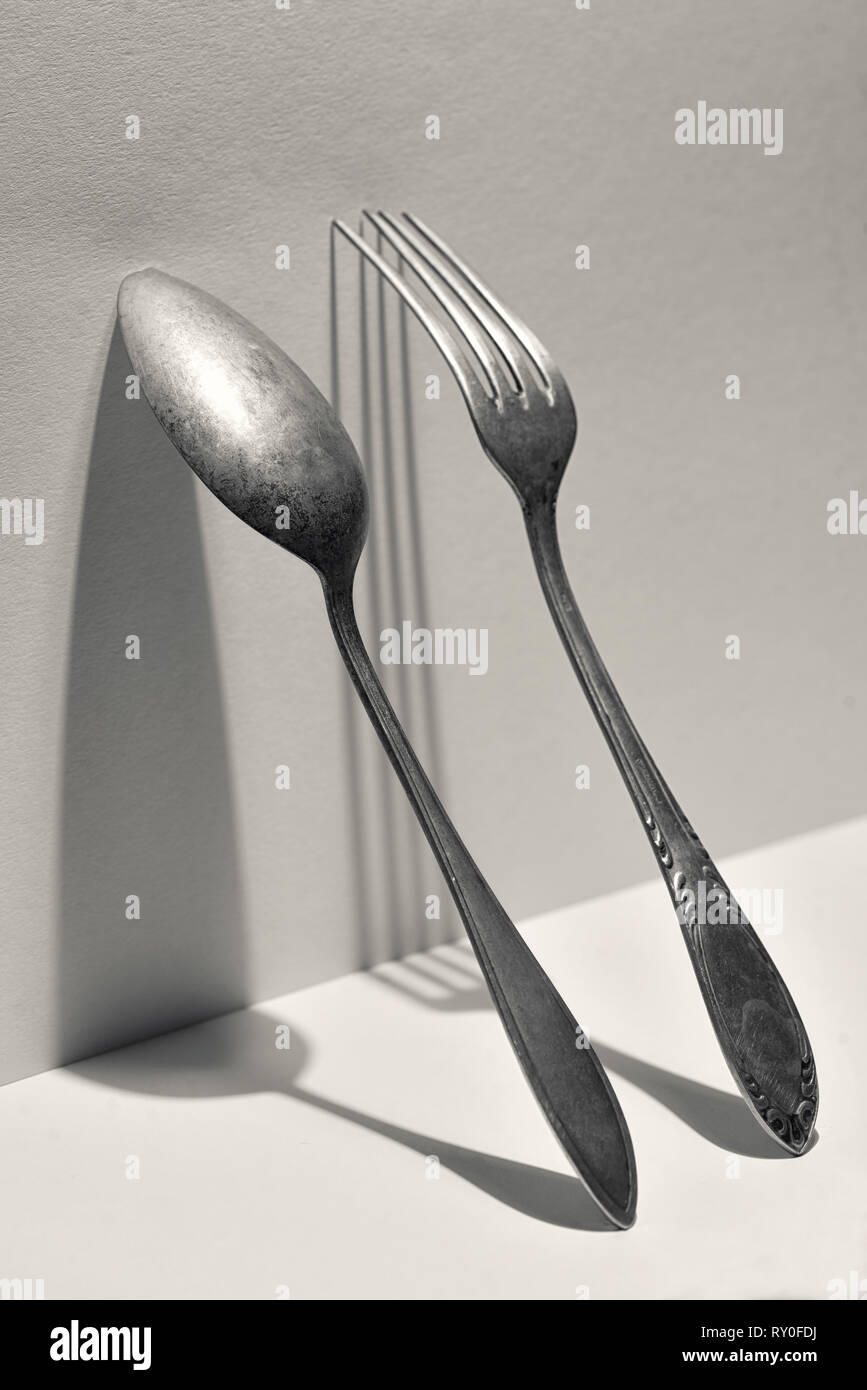 Concetto di argento cucchiaio e forchetta sulla parete Foto Stock