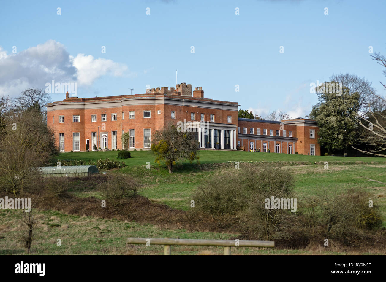 Visualizzare attraverso i campi verso la storica Highfield Park casa nobiliare, ora un hotel nel villaggio di Heckfield, Hampshire. L'ex primo ministro nev Foto Stock