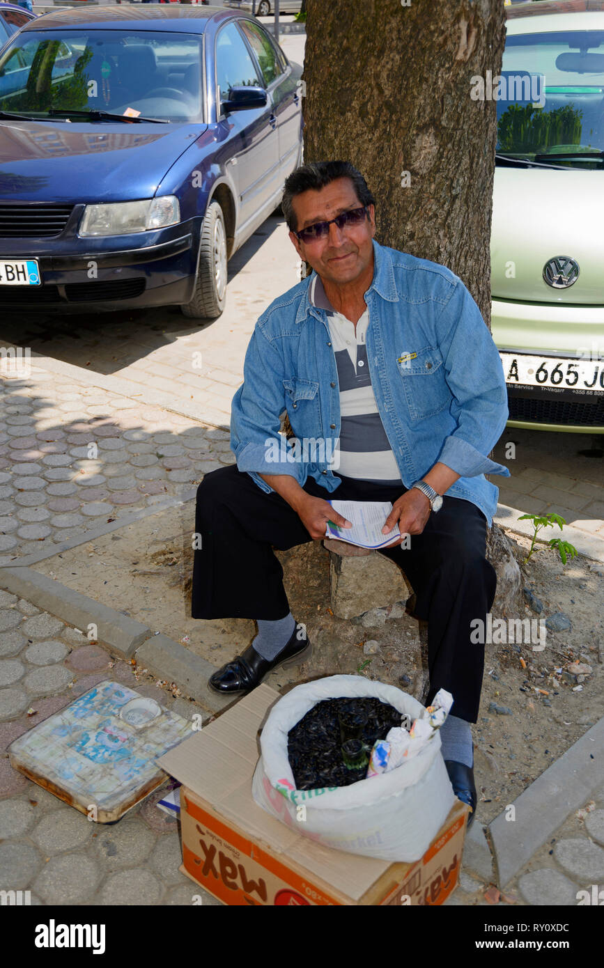 L'uomo le vendite di semi sunflowe, centro città, Korca, Albania, Korça Foto Stock