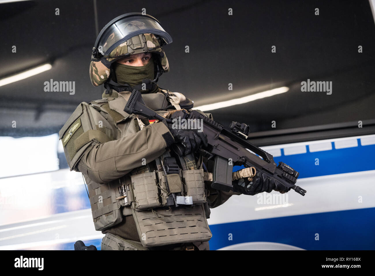 Mainz, Germania. Undicesimo Mar, 2019. Un funzionario di SEK sta con la sua nuova attrezzatura nella parte anteriore di una macchina della polizia. In seguito agli attacchi terroristici a Parigi nel 2015, il Land Renania Palatinato adattato i concetti di tattiche e le attrezzature della FSPC e UFE (prova di conservazione e le unità di arresto) della polizia di fronte alle nuove sfide. Credito: Andreas Arnold/dpa/Alamy Live News Foto Stock
