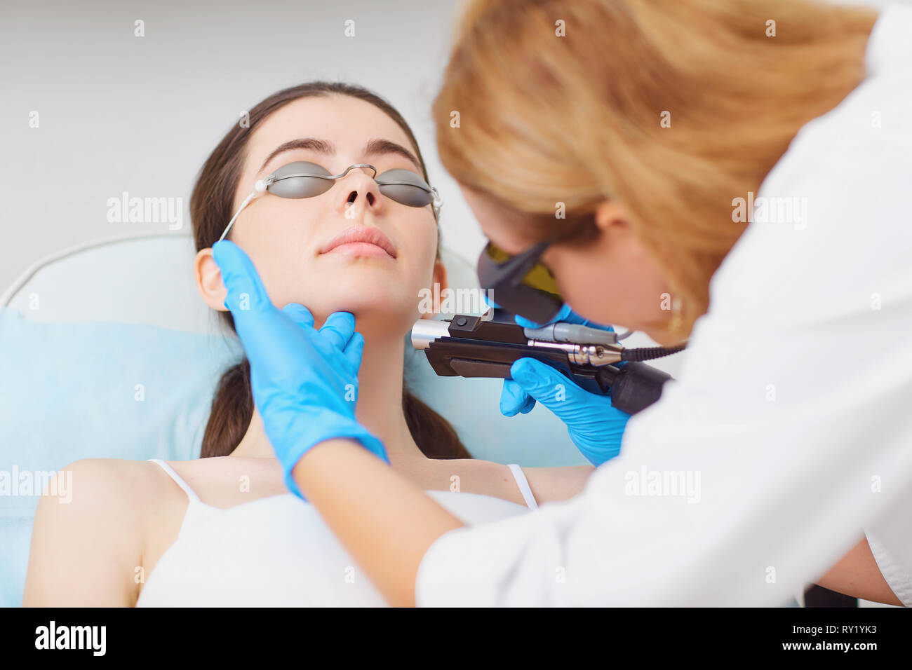 Depilazione laser sul volto di una giovane donna in un cosmetologia Foto Stock