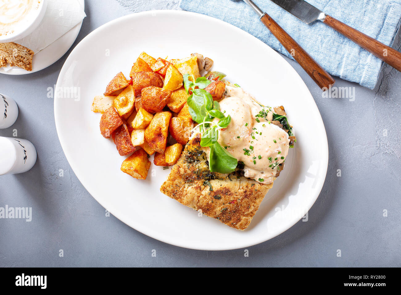 Uova Benedict con focaccia e patate Foto Stock