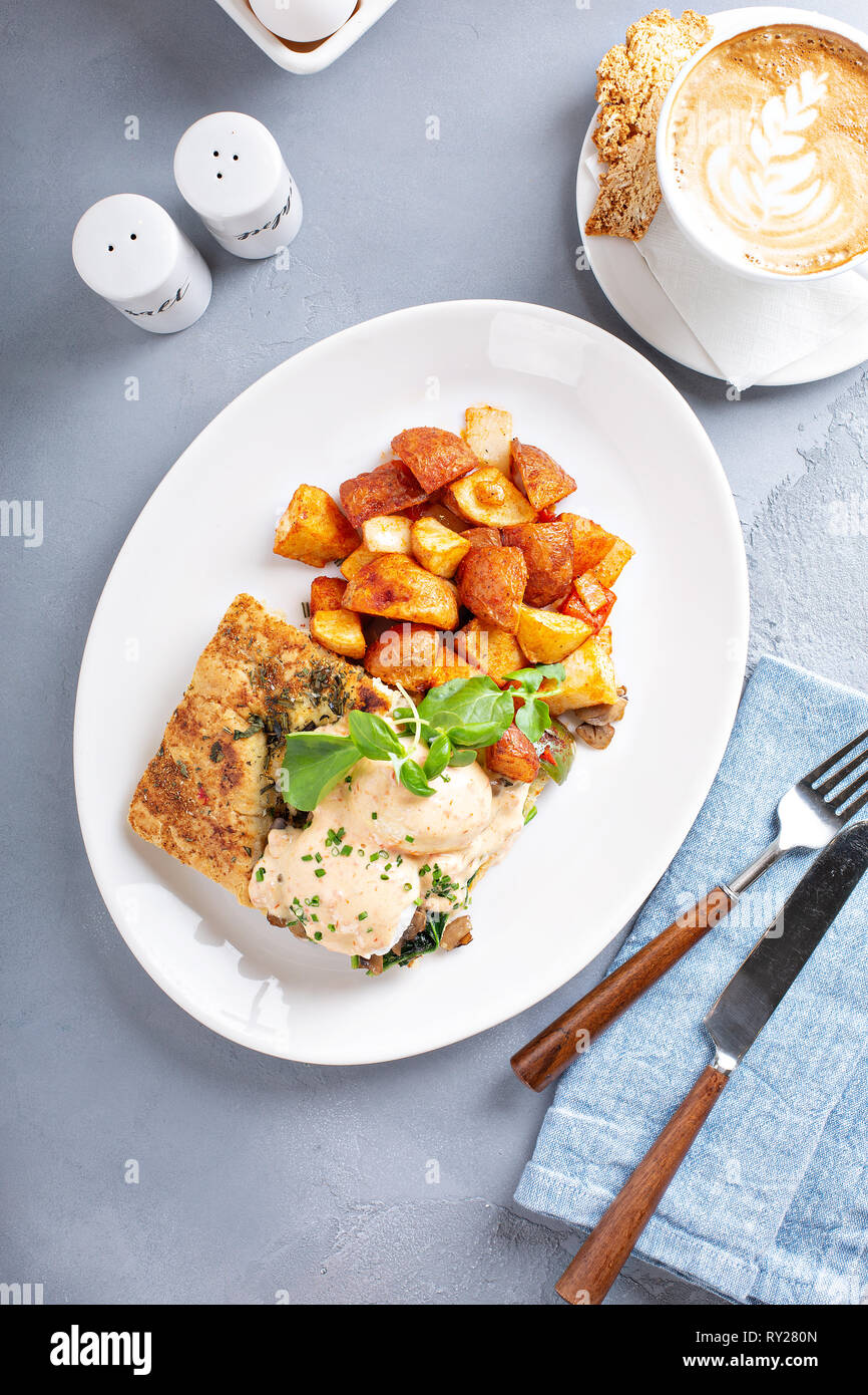 Uova Benedict con focaccia e patate Foto Stock