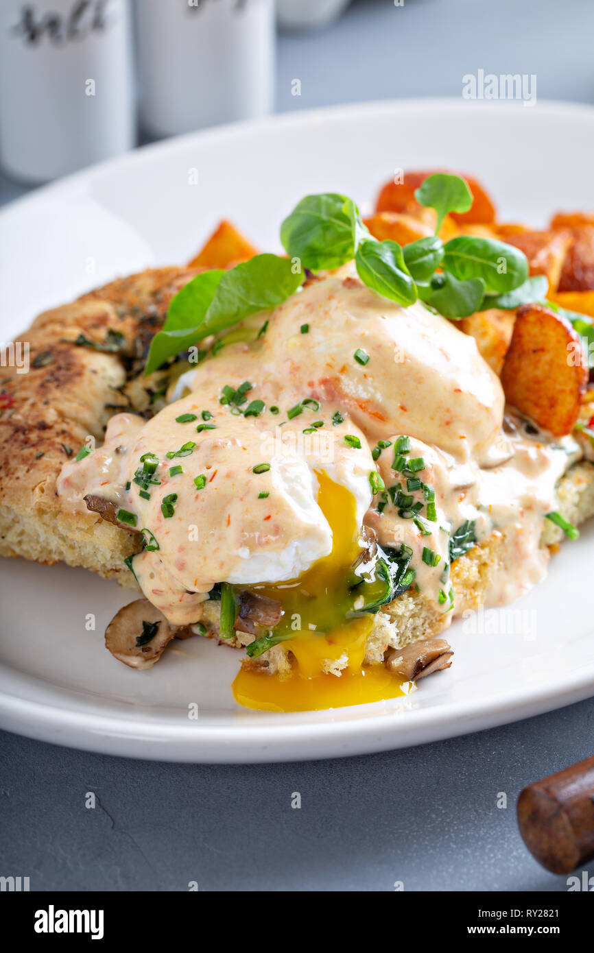 Uova Benedict con focaccia e patate Foto Stock