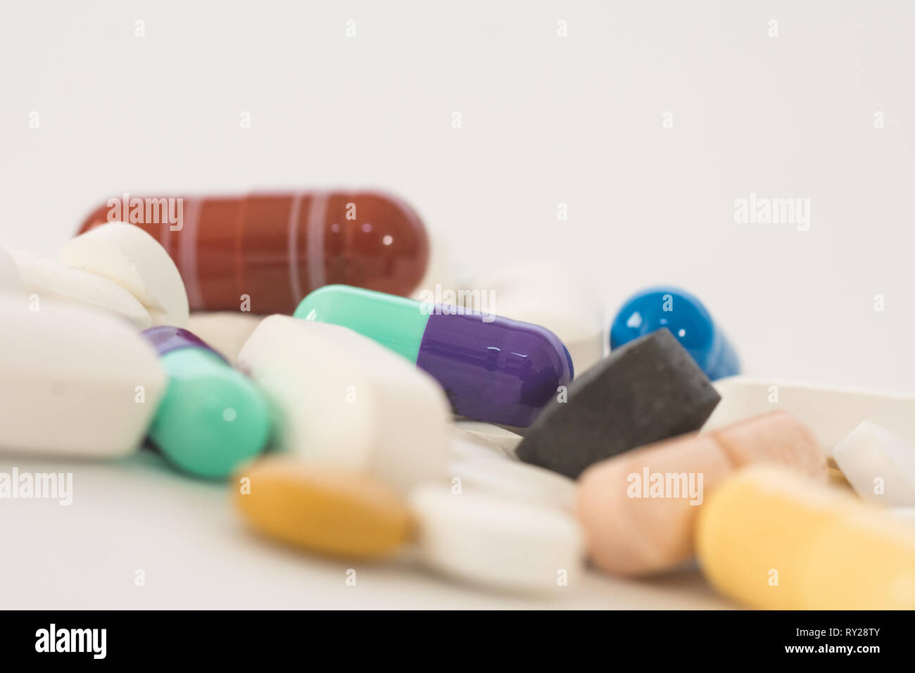 Foto macro di pillole colorate e farmaci isolati su sfondo bianco Foto Stock