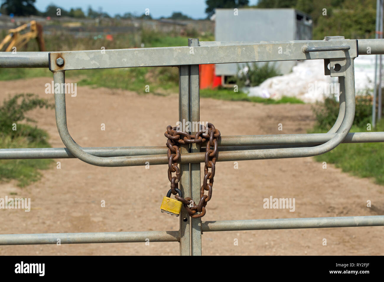 Cancelli di metallo, chiuso e protetto da una pesante catena di metallo e un lucchetto. La protezione della proprietà. Pratico e a vista, psicologico pensare sul wayward passanti.​ Foto Stock