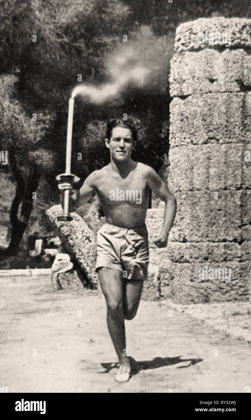 1936 Giochi Olimpici di Berlino - un portatore di torcia porta la torcia olimpica nel corso della prima parte del 3000 Km percorso a Berlino per il 1936 Olimpiadi Foto Stock