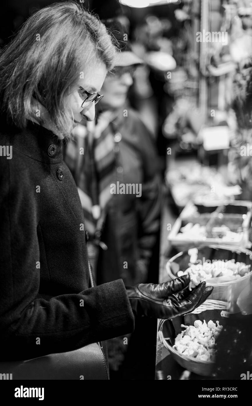 Donna di acquisto di souvenir e giocattoli fatti a mano dalla lana presso il tradizionale mercatino di Natale a Strasburgo Alsazia Foto Stock