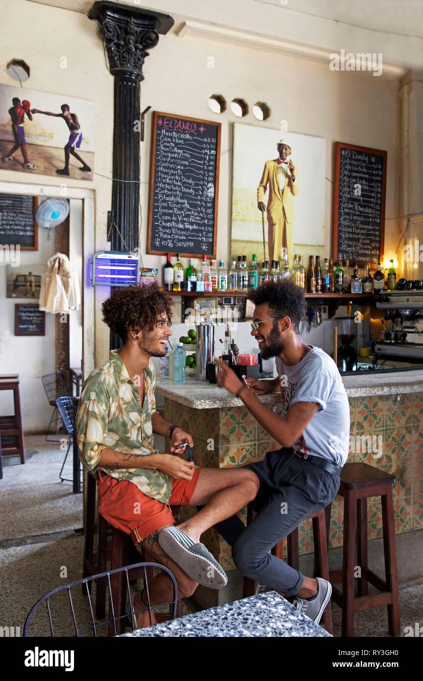 Cuba, La Habana, Havana vecchia, classificato come patrimonio mondiale dall UNESCO, giovani uomini alla moda in seduta il Dandy bar Foto Stock