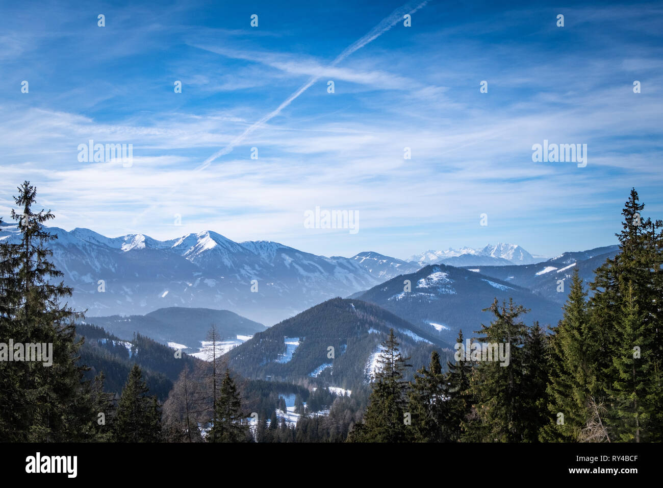 Vista panoramica sulla foresta sul altopiano innevato Kaiserau a monti Tauri Rottenmanner e Dachstein su un soleggiato winterday in Stiria, Austria Foto Stock