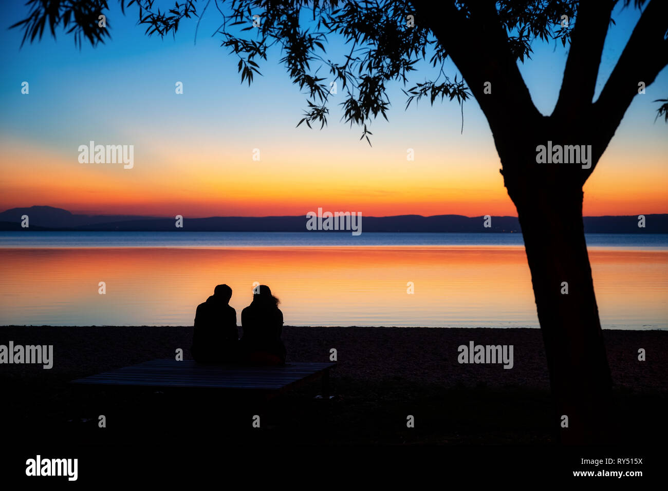 Silhouette di 2 persone a guardare il tramonto in Podersdorf Foto Stock