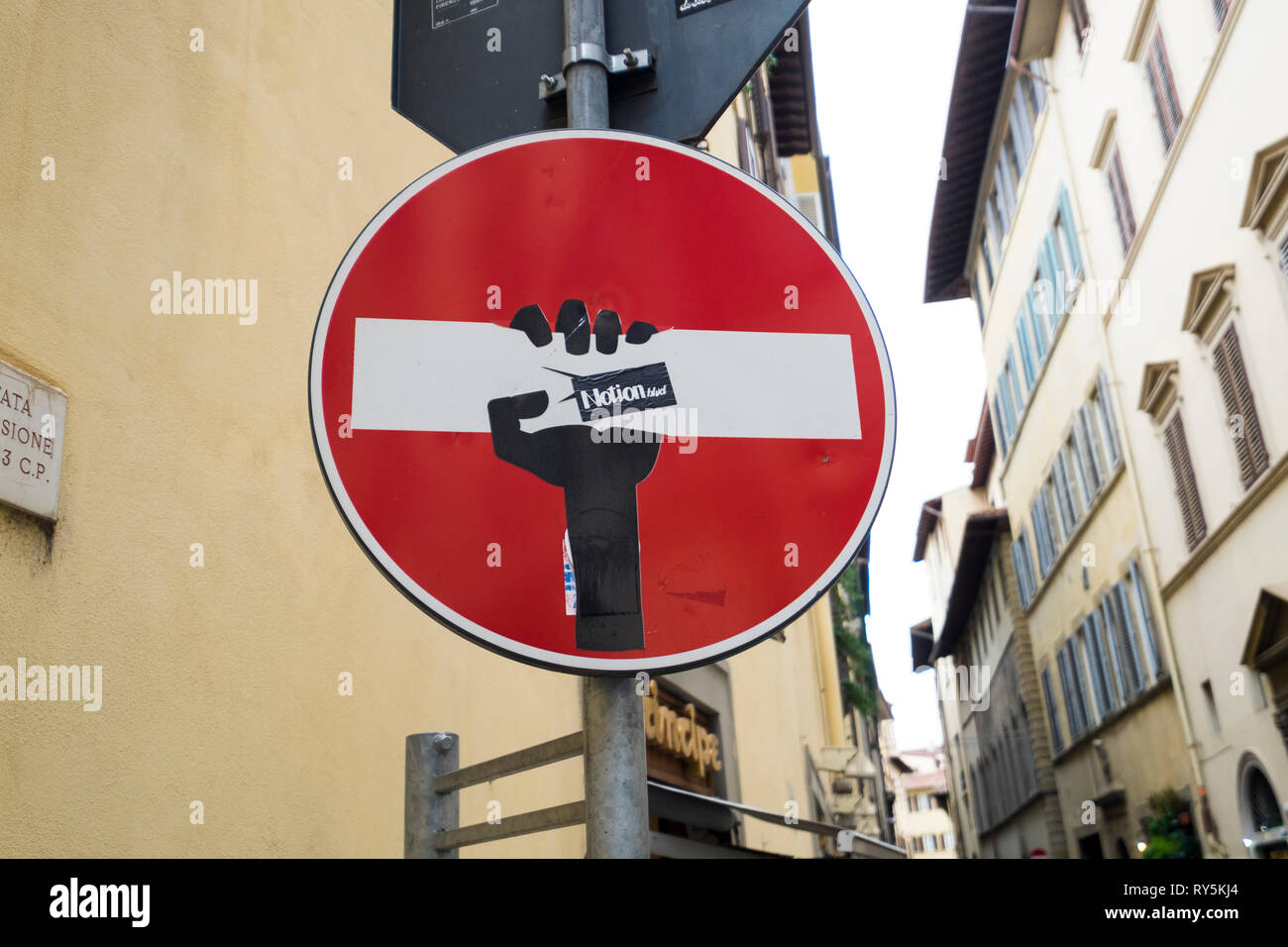 Una mano che stringe il non inserire segno, fatto da un artista Clet, a Firenze, Italia Foto Stock