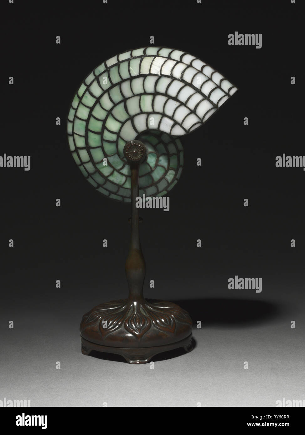 Lampada da scrivania, c. 1900. Studio di Louis Comfort Tiffany (American, 1848-1933). Bronzo, vetro piombato; complessivo: 34,5 x 21,3 x 13,4 cm (13 9/16 x 8 3/8 x 5 1/4 in Foto Stock