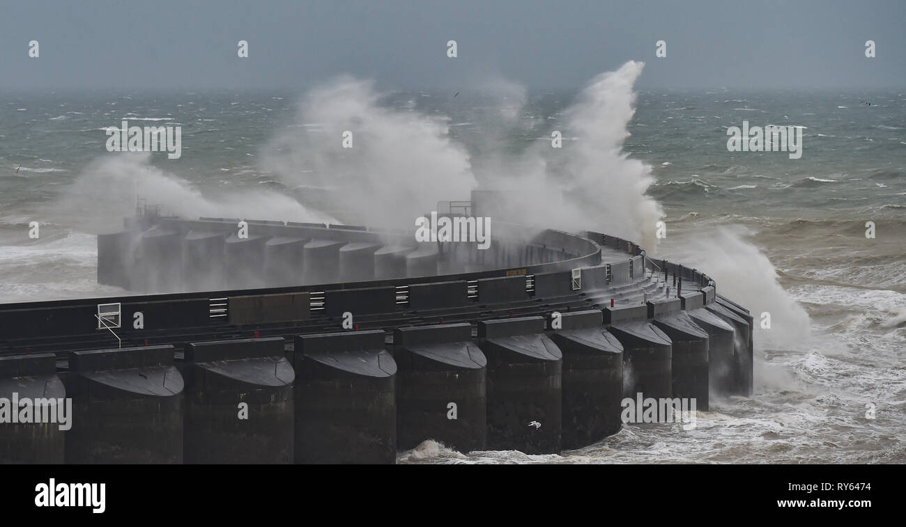 Brighton, Regno Unito. Xii Mar, 2019. Onde infrangersi su Brighton Marina parete occidentale questa mattina come tempesta Gareth inizia a pastella la Gran Bretagna e l'Irlanda con venti dovrebbe raggiungere oltre 70mph in alcune aree Credito: Simon Dack/Alamy Live News Foto Stock