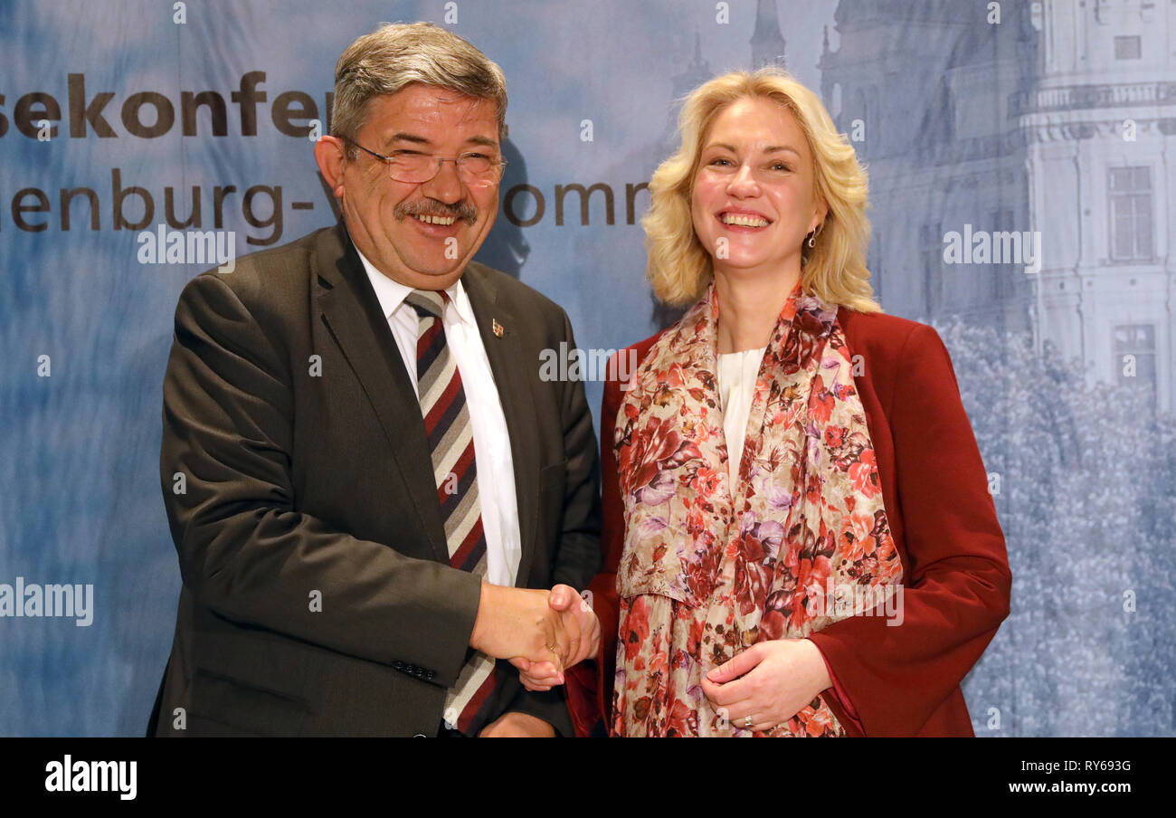 Schwerin, Germania. Xii Mar, 2019. Manuela Schwesig (SPD), il primo ministro del Land Meclemburgo-Pomerania occidentale, e Lorenz Caffier (CDU), vice primo ministro, agitare le mani dopo lo stato conferenza stampa sui risultati intermedi del rosso-nero governo dello stato. Credito: Bernd Wüstneck/dpa/Alamy Live News Foto Stock