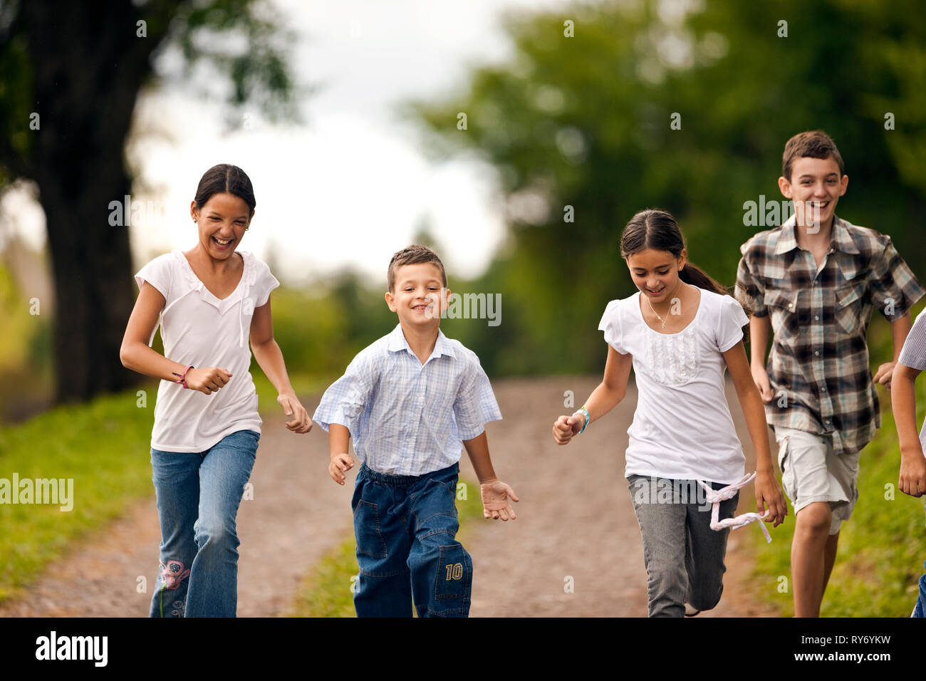 Piccolo gruppo di bambini in esecuzione insieme sulla strada di ghiaia. Foto Stock