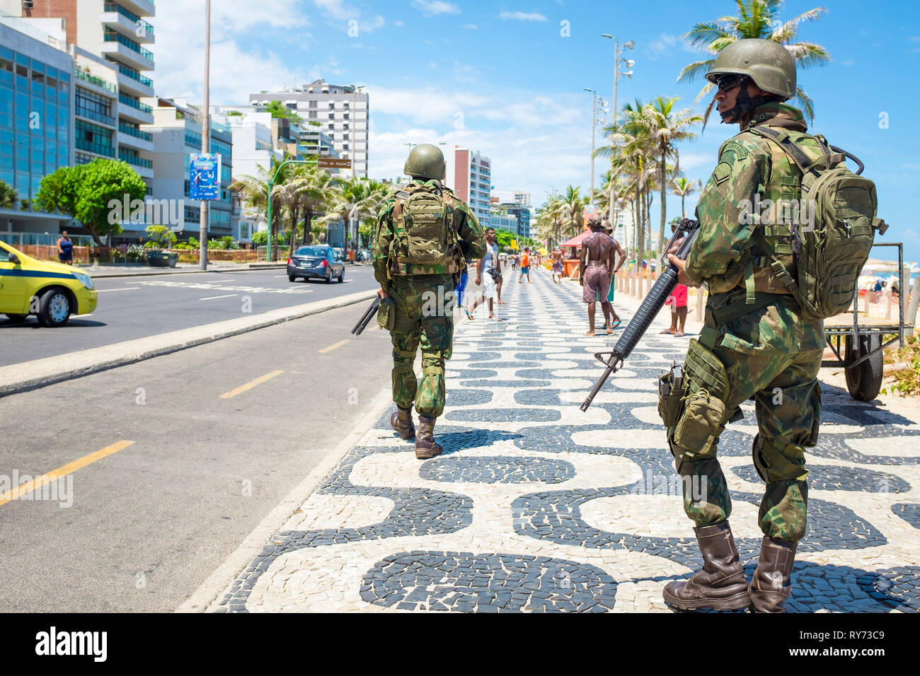 RIO DE JANEIRO - Febbraio 10, 2017: una coppia di elementi armati brasiliano soldati dell esercito pattugliano il Boardwalk presso la spiaggia di Ipanema con fucili a fornire sicurezza. Foto Stock